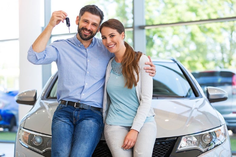 happy couple holding up car keys